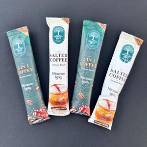 May include: Four individual packets of Vietnamese coffee, two are labeled "3 in 1 Coffee" and two are labeled "Salted Coffee". Each packet features a green logo with a tree and the text "Heritage 1857".