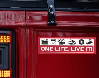 May include: Red car with a white sticker that says "ONE LIFE, LIVE IT!" with black icons of a clapperboard, director's chair, film camera, film strip, camera lens, and a security camera.