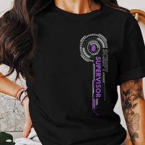 Pode incluir: T-shirt preta com um design gráfico para um supervisor de roteiro. O design inclui um elemento circular e as palavras "SCRIPT SUPERVISOR" em layout vertical, com detalhes roxos e cinzentos.
