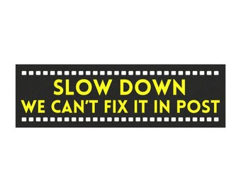 May include: Black and white film strip with yellow text that reads "Slow Down We Can't Fix It In Post"