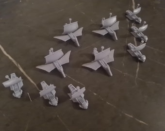 May include: A collection of ten gray plastic model ships with sails. The ships are all the same design, but are in different stages of assembly.