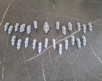 May include: A collection of 25 white miniature ships, some with sails, arranged in a symmetrical pattern on a gray surface.