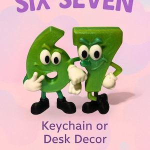 May include: A whimsical green number six and seven keychain or desk decor. The numbers have cartoon-like features with white gloves and black shoes. The text "SIX SEVEN" is above the numbers, and "Keychain or Desk Decor" is below.