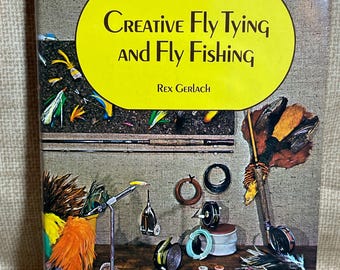 May include: A book titled "Creative Fly Tying and Fly Fishing" by Rex Gerlach. The cover features a colorful illustration of fly fishing equipment and materials, including feathers, thread, hooks, and a vise.