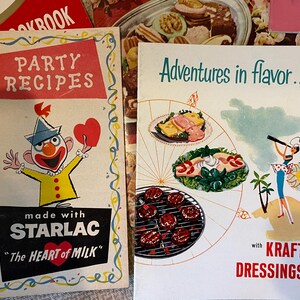 K&ouml;nnte beinhalten: Zwei Vintage-Kochb&uuml;cher mit bunten Umschl&auml;gen. Das erste Kochbuch zeigt einen Comic-Clown mit einem roten Herzen und dem Text "Party-Rezepte mit Starlac "Das Herz der Milch". Das zweite Kochbuch zeigt eine bunte Illustration eines Kompasses mit verschiedenen Lebensmitteln und dem Text "Abenteuer im Geschmack... mit Kraft Dressings".