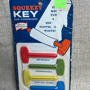 May include: Vintage Squeezy Key for toothpaste tubes. The blue and white packaging features the product name and a graphic of a toothpaste tube. Includes four multi-colored keys: red, green, yellow, and blue. The packaging states the keys are reusable and fit all tubes.