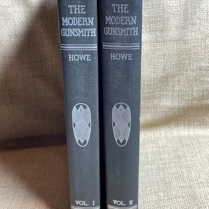 Può includere: Due libri rilegati in tela nera intitolati "The Modern Gunsmith" di Howe, volumi I e II, pubblicati da Funk & Wagnalls Company.
