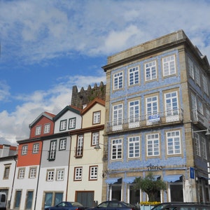 May include: A row of colourful buildings with blue and white tiled facades. The building on the right has a sign that says "Atrio".