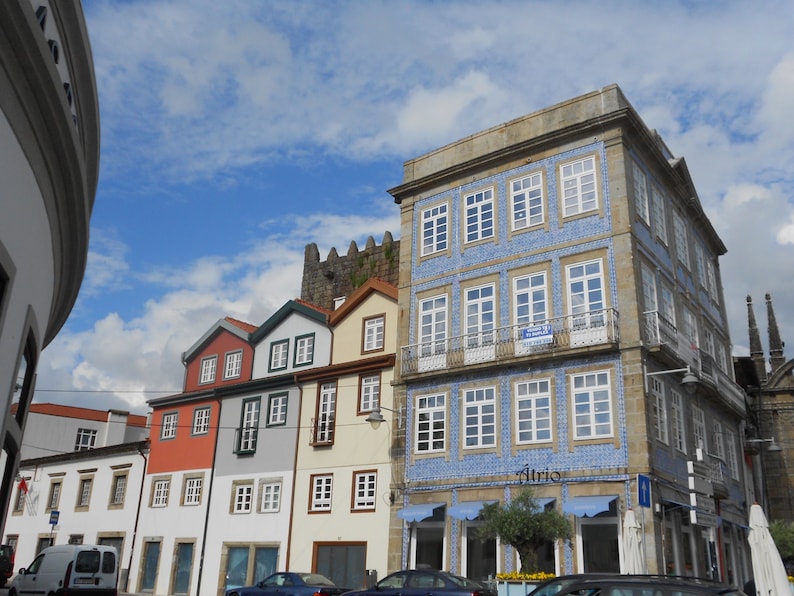May include: A row of colourful buildings with blue and white tiled facades. The building on the right has a sign that says "Atrio".