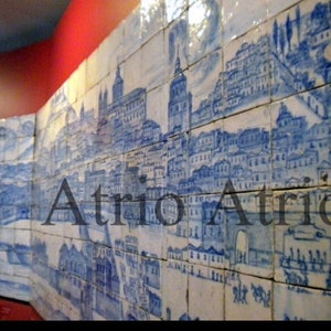May include: A blue and white tiled mural depicting a cityscape with the word "Atrio" in the center. The tiles are arranged in a grid pattern and the cityscape is detailed with buildings, trees, and a river.