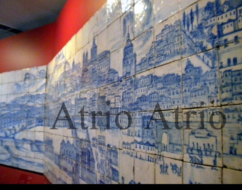 May include: A blue and white tiled mural depicting a cityscape with the word "Atrio" in the center. The tiles are arranged in a grid pattern and the cityscape is detailed with buildings, trees, and a river.