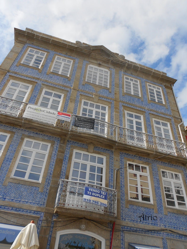 May include: A building with blue and white tiled accents. The building has multiple windows and a sign that reads "VENDO T83 T3 DUPLEX 910 795 356".