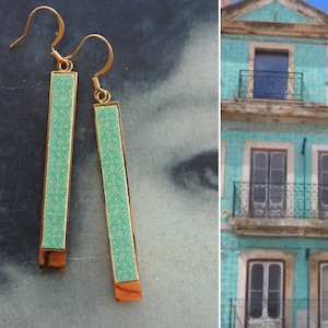 May include: A pair of gold dangle earrings with green rectangular ceramic panels featuring a repeating geometric pattern.