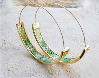 May include: A pair of gold hoop earrings with a green and blue patterned design. The earrings are large and have a wide band.