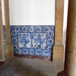 Peut inclure: Un mur blanc avec une bordure de carreaux bleus et blancs. Les carreaux ont un motif floral et sont dispos&eacute;s de mani&egrave;re sym&eacute;trique. Un pilier en pierre se trouve au premier plan.