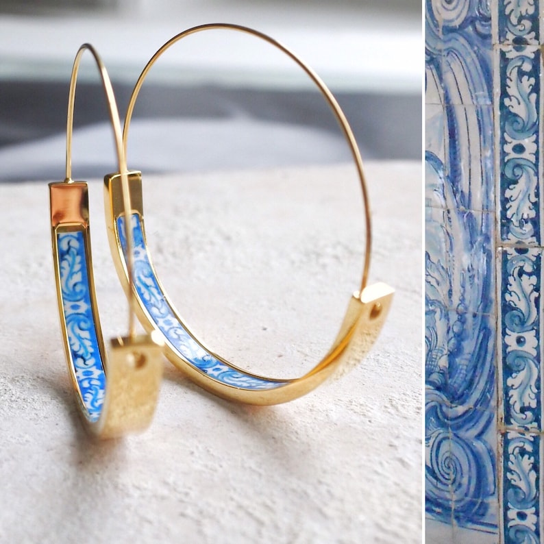 Peut inclure: Boucles d'oreilles cr&eacute;oles dor&eacute;es avec un motif floral bleu et blanc. Le motif rappelle les carreaux traditionnels portugais.