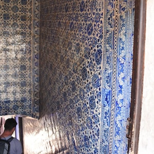May include: A close-up of a staircase with blue and white patterned tiles. The tiles are arranged in a geometric pattern and feature floral motifs. The staircase is lit by natural light, creating a bright and airy atmosphere.