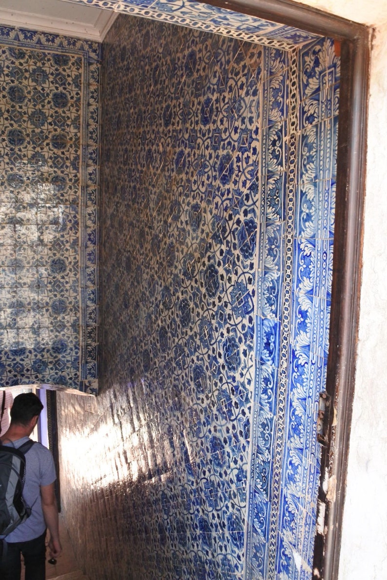 May include: A close-up of a staircase with blue and white patterned tiles. The tiles are arranged in a geometric pattern and feature floral motifs. The staircase is lit by natural light, creating a bright and airy atmosphere.