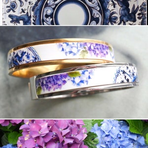 May include: Two gold and silver bracelets with a white background and a floral design of purple and blue hydrangeas.