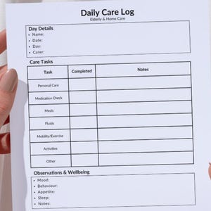 May include: A white Daily Care Log for Elderly & Home Care, held by hands. The log includes sections for day details, care tasks, observations, and notes. The text on the log includes "Name", "Date", "Day", "Carer", "Task", "Completed", and "Notes".