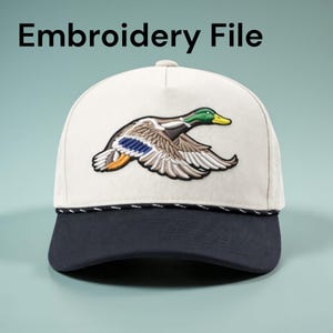 May include: A baseball cap with a white crown and a navy blue brim. The cap features an embroidered mallard duck in flight, with green, brown, and blue details. The text "Embroidery File" is above the cap.