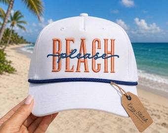 May include: A white baseball cap featuring the embroidered text BEACH in orange block letters with the word please in blue cursive script overlaid. A dark blue rope trim sits above the brim, and a brown paper tag reads Eazy Stitch.