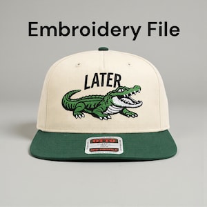 Puede incluir: Gorra de béisbol color crema con visera verde y diseño de cocodrilo bordado en verde. La palabra "LATER" está encima del cocodrilo. La gorra tiene un ajuste clásico de perfil medio.