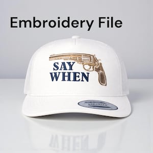 Puede incluir: Gorra de camionero blanca con parte trasera de malla y visera curva. La gorra presenta un diseño bordado de un revólver con el texto "SAY WHEN" en azul marino. El texto "Embroidery File" está arriba.