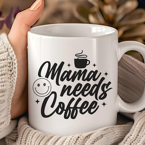 May include: White ceramic coffee mug with the text "Mama needs Coffee" in black script. The design includes a smiling face, a coffee cup icon, and star accents. The mug has a curved handle.