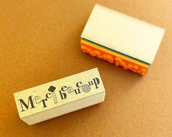 May include: Two wooden stamps, one with the text "Merci beaucoup" and the other with a variety of colorful designs.