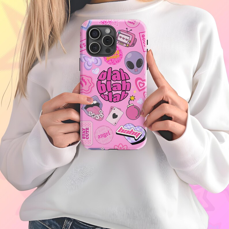 May include: A pink phone case with a variety of colorful stickers and the words "blah blah blah" in pink.