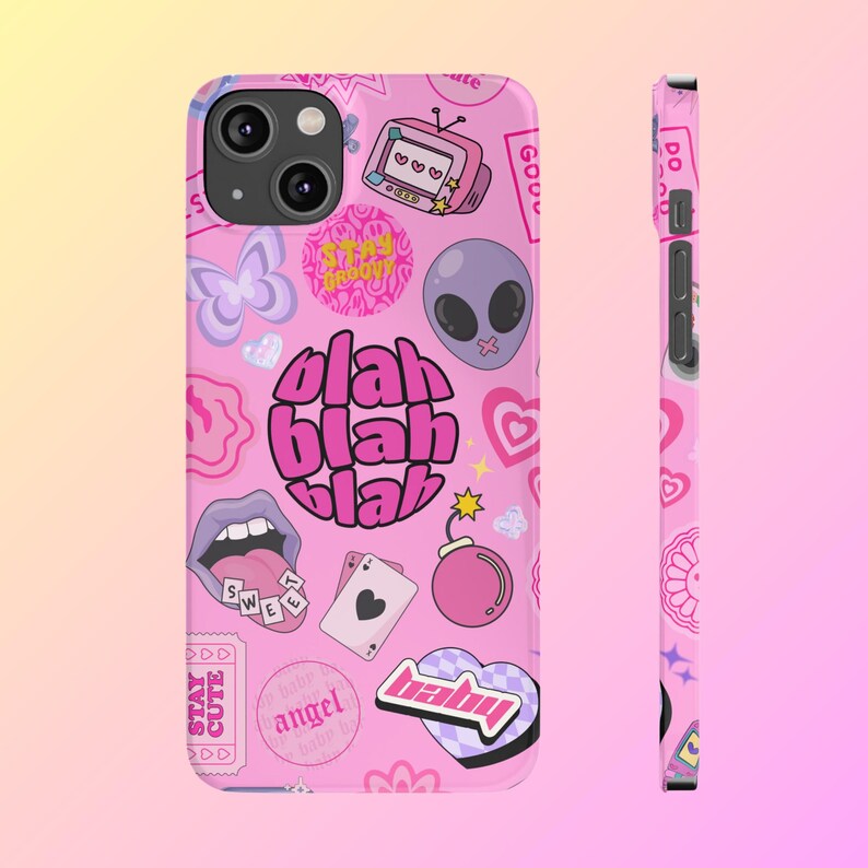 May include: Pink iPhone case with a variety of colorful stickers and graphics, including a butterfly, a heart, a bomb, a mouth with a tongue sticking out, a playing card, an alien, and the text "blah blah blah".