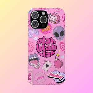 May include: Pink phone case with a variety of colorful stickers and graphics, including a cartoon alien, a bomb, a heart, a mouth, and the words "blah blah blah".