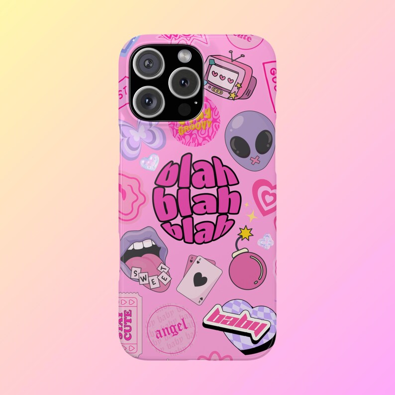 May include: Pink phone case with a variety of colorful stickers and graphics, including a cartoon alien, a bomb, a heart, a mouth, and the words "blah blah blah".