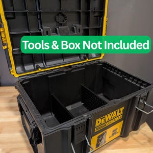 May include: Black and yellow DEWALT TOUGH SYSTEM 2.0 toolbox, open to reveal interior compartments. The lid is open, showing the interior. The text "Tools & Box Not Included" is visible. The toolbox is on a wooden surface.