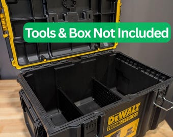 Pode incluir: Caixa de ferramentas preta e amarela DEWALT TOUGH SYSTEM 2.0, aberta para revelar os compartimentos internos. A tampa está aberta, mostrando o interior. O texto "Tools & Box Not Included" é visível. A caixa está sobre uma superfície de madeira.