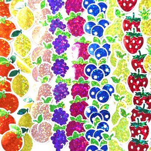 May include: A vibrant assortment of fruit stickers, including apples, oranges, lemons, grapes, raspberries, blueberries, strawberries, pineapples, and cherries. Each sticker has a glittery finish, creating a colorful and eye-catching design.