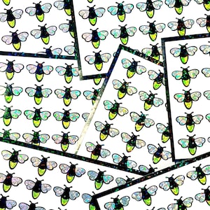 May include: Sheets of stickers featuring a repeating pattern of stylized fireflies. Each firefly has a black body, iridescent wings, and a yellow-green glowing abdomen. The stickers are arranged on white backgrounds.