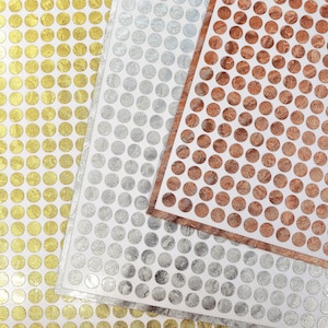 May include: Three sheets of paper with a repeating pattern of circles in gold, silver, and copper.