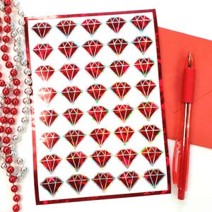 May include: A sheet of red holographic diamond stickers. The stickers are arranged in a grid pattern on a white background.