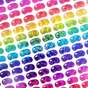May include: A sheet of iridescent holographic jelly bean stickers in a rainbow of colors. The stickers are arranged in a diagonal pattern.