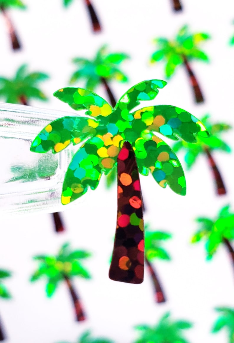 Op de afbeelding: Een groene, glinsterende glitter-palmboom met een rode, oranje en groene glitter-stam. De palmboom staat op een witte achtergrond.