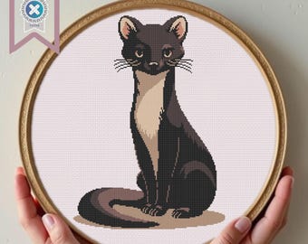 Può includere: Schema a punto croce di un gatto nero e marrone seduto in posizione eretta, incorniciato in un cerchio di legno. Il gatto ha una lunga coda e baffi. Un banner in alto a sinistra recita "PDF Download".