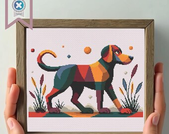 May include: A framed cross-stitch of a dog in a geometric design. The dog is depicted in shades of green, orange, and red, with a light pink background. The frame is made of wood. The image includes the text "PDF Download".
