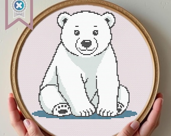 May include: A white polar bear cub sitting on a blue background. The bear has black eyes and a black nose.