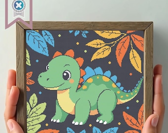 May include: A framed cross-stitch featuring a green dinosaur with orange and yellow accents, set against a dark blue background with colorful leaves. The frame is a light brown color. The image is held by two hands.