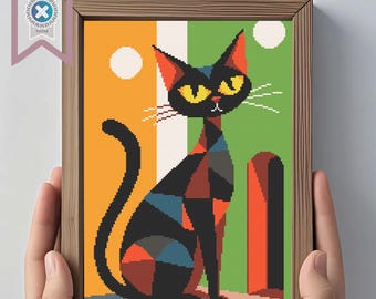 May include: A framed cross-stitch art piece featuring a stylized black cat with yellow eyes, set against a backdrop of orange and green vertical stripes. The cat's body is composed of geometric shapes in various colors. The frame is made of wood.