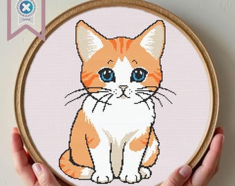 May include: Cross-stitch pattern of a cute orange and white kitten with blue eyes sitting on a pink background.