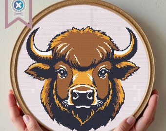 May include: A close-up of a brown and black yak head with a white background. The yak has a large, furry head with a long, black nose and large, dark eyes.
