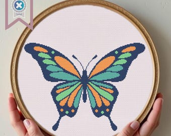 May include: A cross-stitch embroidery hoop with a colorful butterfly design. The butterfly has orange, green, and blue wings.